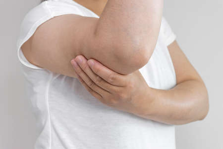 A woman holding her upper arm (Japanese, 30s, no face)の写真素材