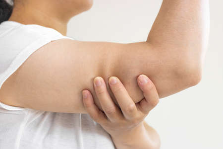 A woman holding her upper arm (Japanese, 30s, no face)の写真素材