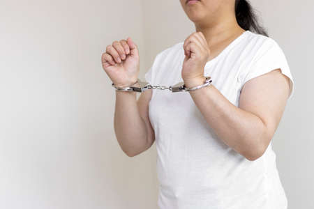 A woman wearing handcuffs (30s, Japanese, no face). Image of arrestの写真素材