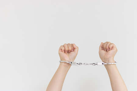 A woman wearing handcuffs (30s, Japanese, no face). Image of arrestの写真素材