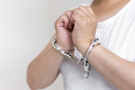 A woman wearing handcuffs (30s, Japanese, no face). Image of arrestの写真素材