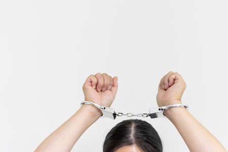 A woman wearing handcuffs (30s, Japanese, no face). Image of arrestの写真素材