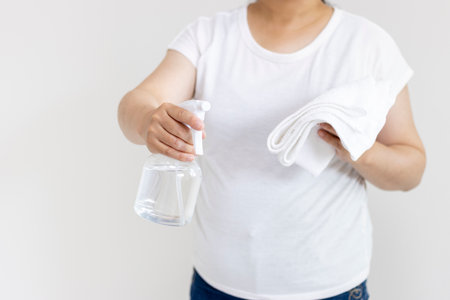 Cleaning image of a woman with a towel and spray (Japanese, 30s, no face)の写真素材