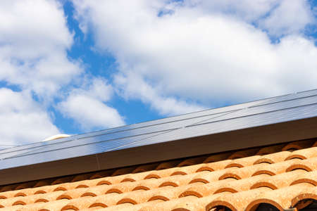 Roof with solar panels and blue sky