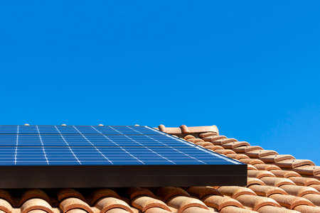 Roof with solar panels and blue sky