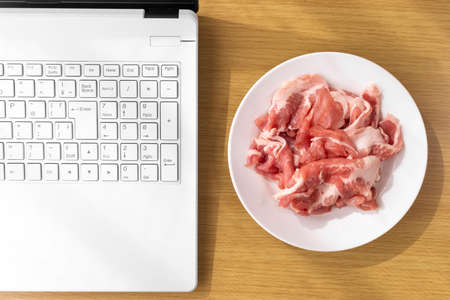 Image of looking up recipes for pork dishes on a laptopの写真素材