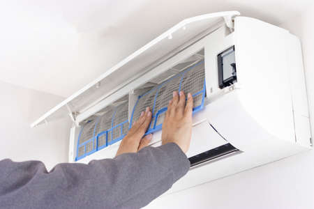 Image of a man cleaning an air conditioner filterの写真素材