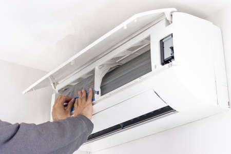 Image of a man cleaning an air conditioner filterの写真素材
