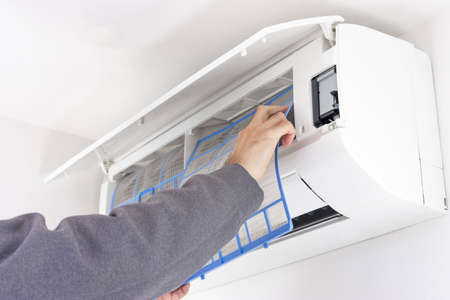 Image of a man cleaning an air conditioner filterの写真素材