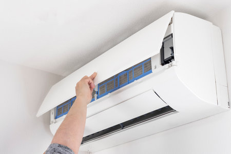 Image of a woman cleaning an air conditioner filterの写真素材
