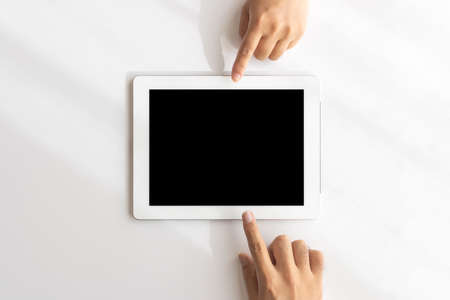 Men's and women's hands pointing to a tablet device (Japanese, 30s)の写真素材