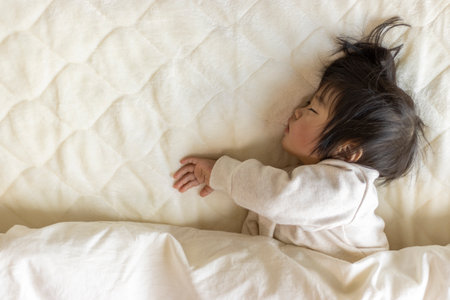 Baby taking a nap on a futon (1 year and 5 months old, Japanese, girl)の写真素材