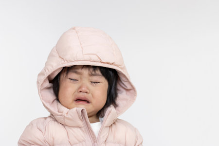 A crying baby wearing a down jacket (1 year and 5 months old, Japanese, girl)の写真素材