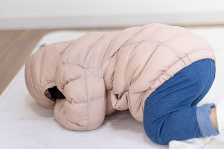 A baby wearing a down jacket and crying (1 year and 5 months old, Japanese, girl)の写真素材