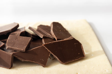 Broken chocolate bar and puff pastry. Image of making chocolate pieの写真素材