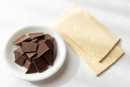 Broken chocolate bar and puff pastry. Image of making chocolate pieの写真素材