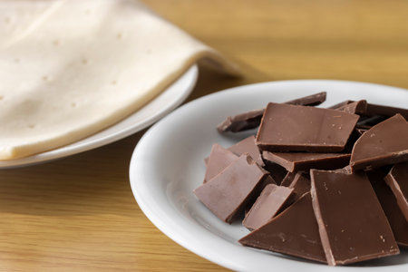 Broken chocolate bar and puff pastry. Image of making chocolate pieの写真素材