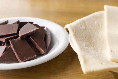 Broken chocolate bar and puff pastry. Image of making chocolate pieの写真素材