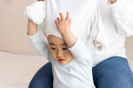 Changing clothes for a baby (1 year and 8 months old, girl, Japanese)の写真素材