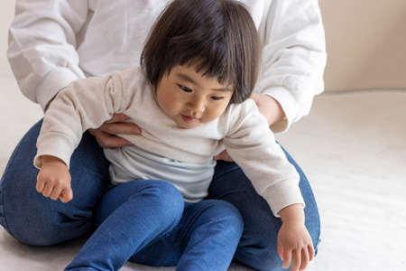 Changing clothes for a baby (1 year and 8 months old, girl, Japanese)の写真素材