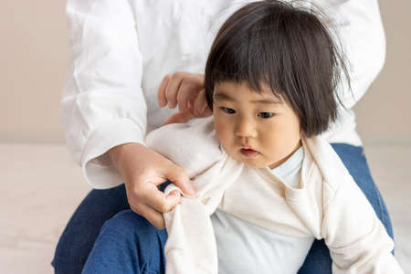 Changing clothes for a baby (1 year and 8 months old, girl, Japanese)の写真素材