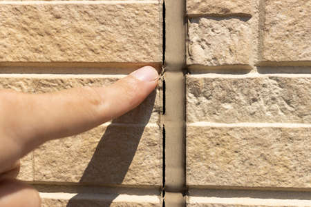 Image of a man inspecting caulking on the outer wallの写真素材