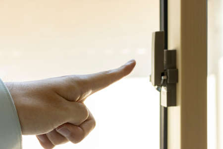 Man's hand checking the window keyの写真素材