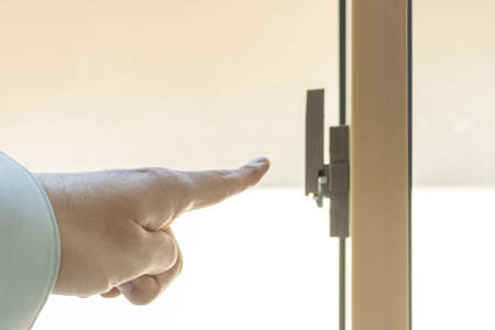 Man's hand checking the window keyの写真素材