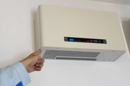 Man's hand to check the power conditionerの写真素材