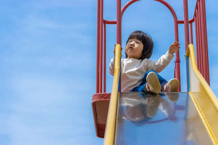 Baby playing on the slide (1 year and 10 months old, girl, Japanese)の写真素材