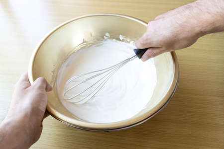 Image of a man whisk cream with a whiskの写真素材