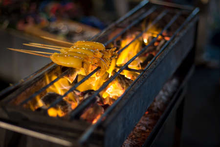 Squid on the grill with a flame.の写真素材