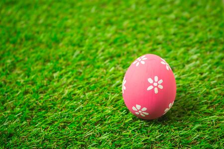 Pink easter egg painting colorful during the Easter and artificial grass green. Pink easter eggs on...