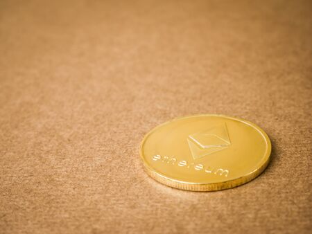 Ethereum coin and gold on a brown background. Business value ethereum coins are expensive.