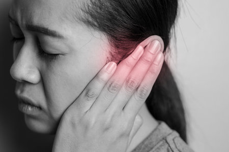 Black and white young woman with of earache on a gray background. Asian  woman is suffering of earache. Women with a lot of ear pain.の写真素材