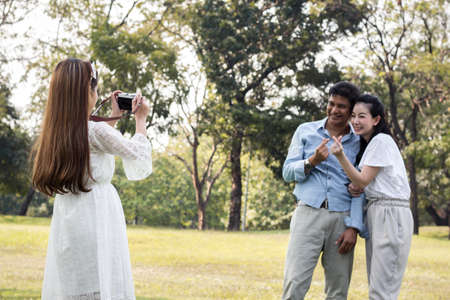 Father and mother let his daughter take pictures as souvenirs in the park. Children are take a photo for parents.の写真素材