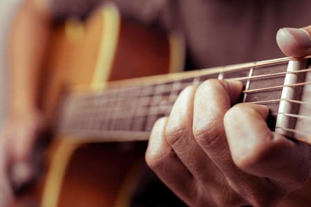 Male musicians playing acoustic guitar. Closeup musicians are playing acoustic guitar. Male...