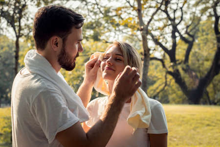 Young man wiped the sweat for his girlfriend after exercising together with tenderness. Concept...