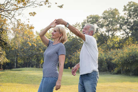 Senior couples dance together on the lawn in the park. Concept, healthy senior couples.