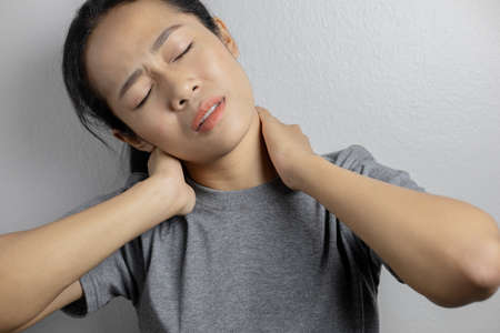 Woman with pain in neck. Concept woman suffering from pain in neck.の写真素材