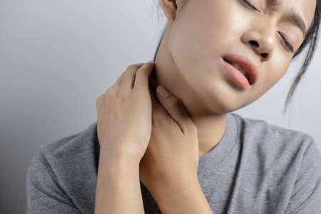 Woman with pain in neck. Concept woman suffering from pain in neck.の写真素材