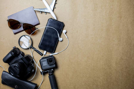 Top view of accessories used for leisure travelers on a brown background. Travel accessories and...