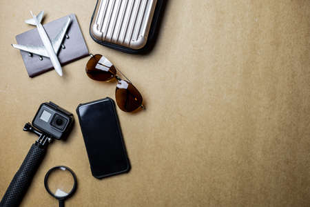 Top view of accessories used for leisure travelers on a brown background. Travel accessories and...