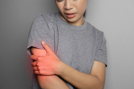 Woman suffering from pain in arm. Concept pain in arm. Young woman with pain in arm.
