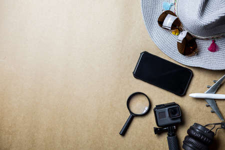 Top view of accessories used for leisure travelers on a brown background. Travel accessories and copy space. Concept of top view travel accessories.の写真素材