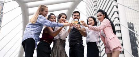 Business people clink glasses and drink wine to celebrate the successful work. Group of business...