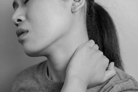 Woman with pain in neck. Concept woman suffering from pain in neck.の写真素材