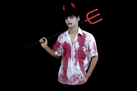 Young Asian man costume in hell, evil on black background with concept for Halloween fashion festival in studio. Teen Asian man in cosplay Halloween.の写真素材