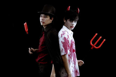 Young Asian men in costume hell, evil and wizard with fight on black background with concept for...