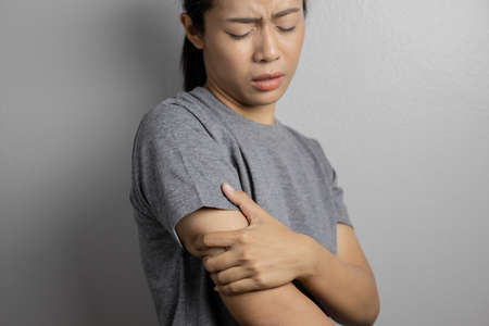 Woman suffering from pain in arm. Concept pain in arm. Young woman with pain in arm.